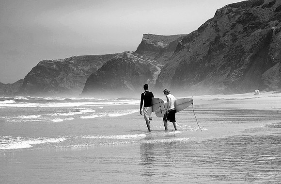 surfers walk to the waves